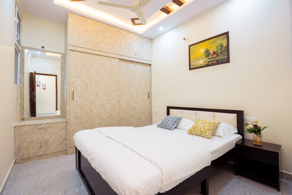 Un dormitorio con cama, mesita de noche y un cuadro en la pared.