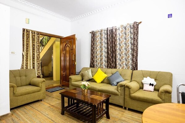 A living room with two sofas, a coffee table, and a staircase leading to another room.