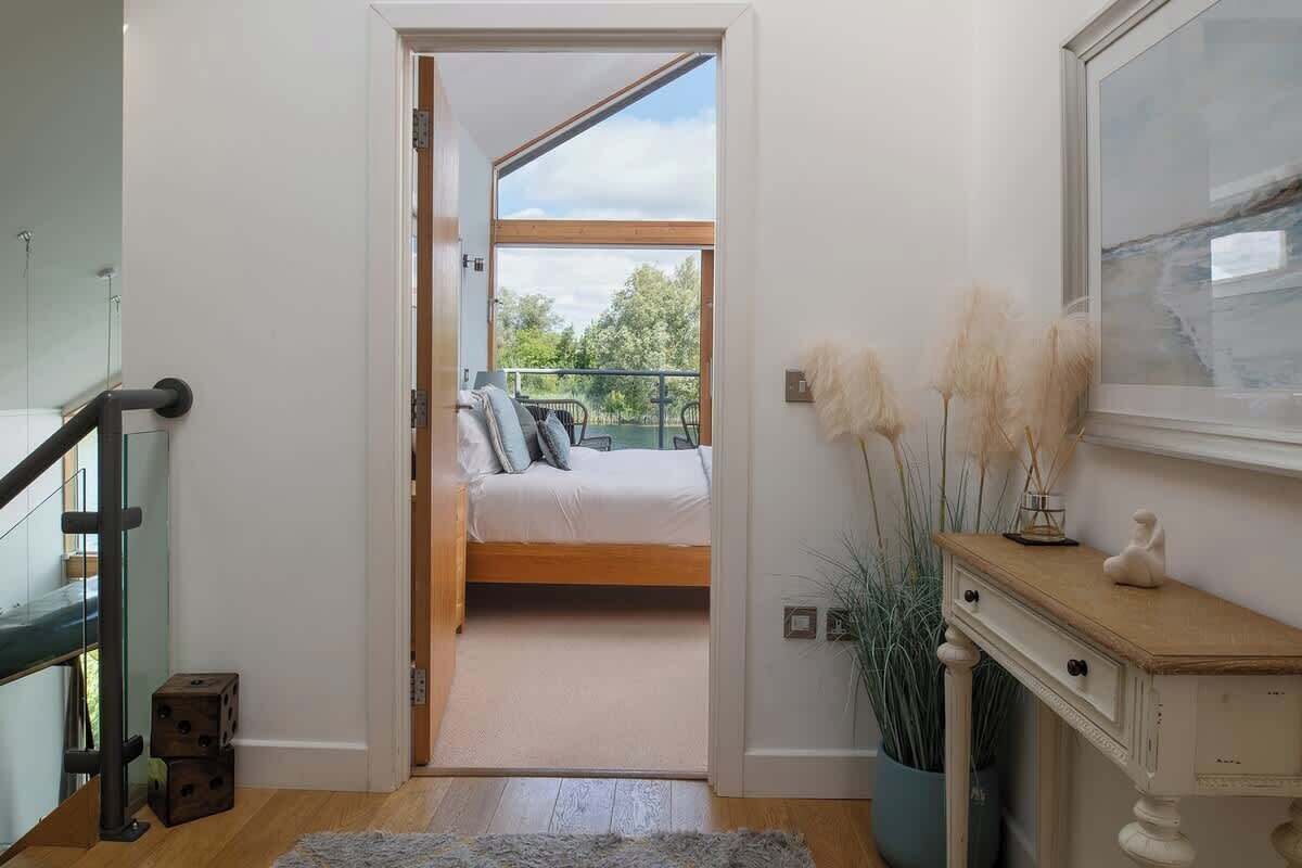 A bedroom with a bed, a nightstand, a dresser, and a window with a view of greenery.