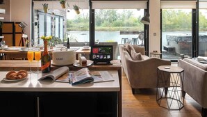 A modern kitchen with a large island, a dining area with a view, and a cozy seating area with a sofa and a coffee table.