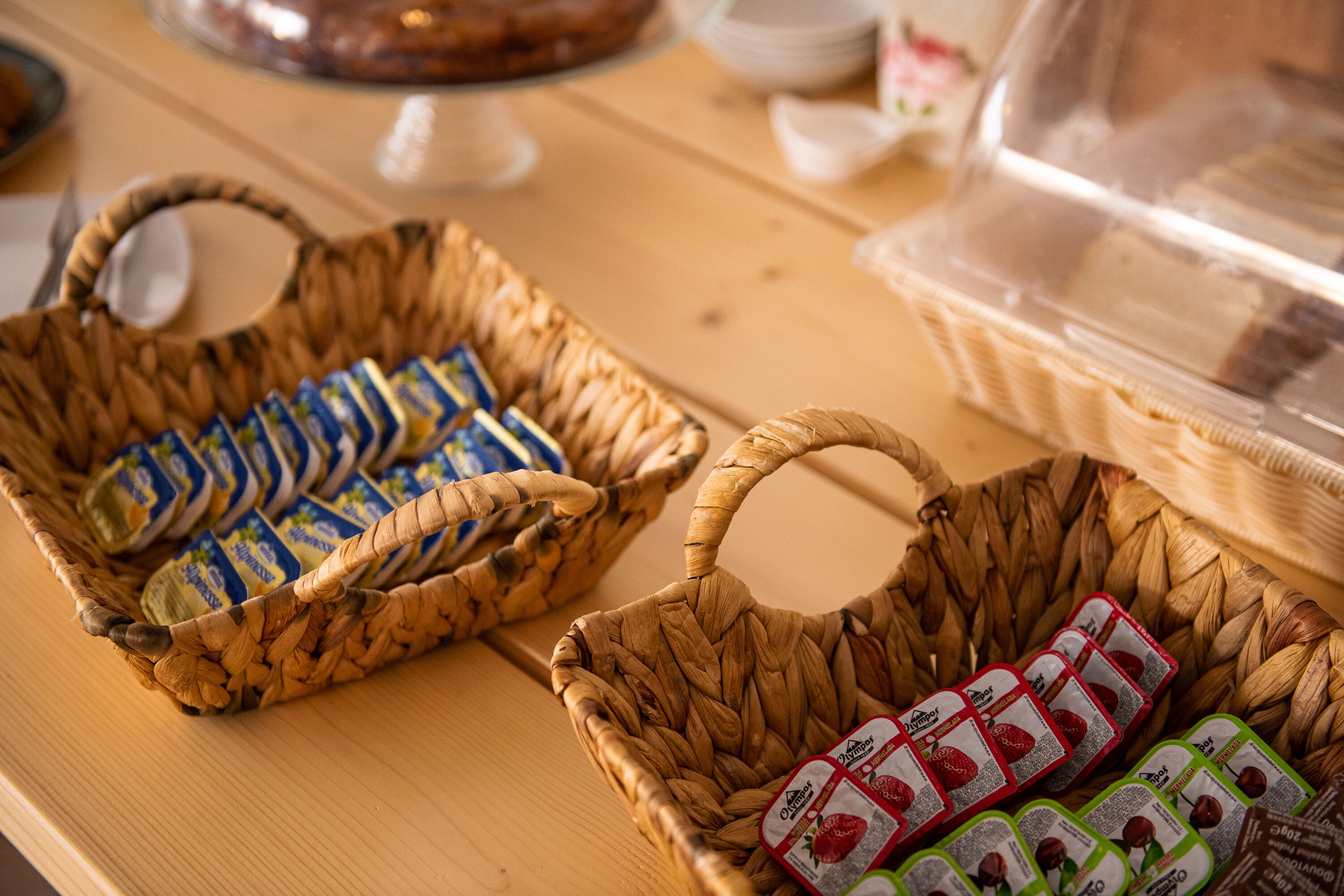 Deux paniers en osier, posés sur une table en bois, et contenant chacun des produits alimentaires emballés.