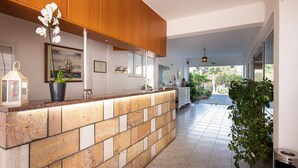 A modern kitchen with a stone island, wooden cabinets, and a potted orchid. - Zoe Seaside (Istiaia-Aidipsos)