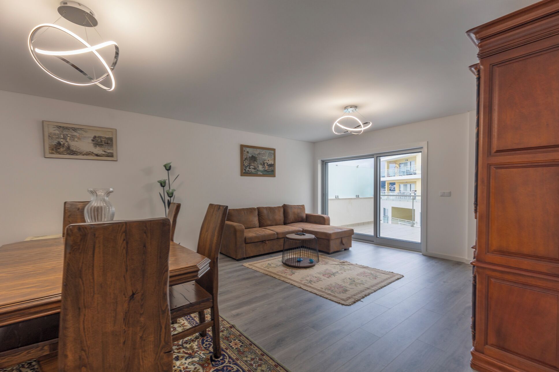 Un salón espacioso con una mesa de comedor de madera, un sofá de cuero marrón y un gran aparador de madera.