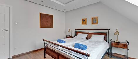 A bedroom with a wooden bed, two bedside tables, and a ceiling light.
