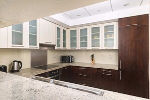 A kitchen with a microwave, kettle, and stainless steel appliances. - Panoramic Terrace & Burj Khalifa View (Dubai)
