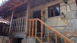A stone building with a wooden staircase and a balcony. - Casas do Souto (Lousada)