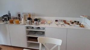A breakfast buffet setup with various food items and beverages. - Casas do Souto (Lousada)