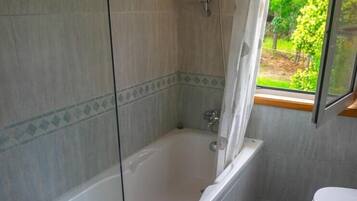 A bathroom with a bathtub, a shower, and a toilet.