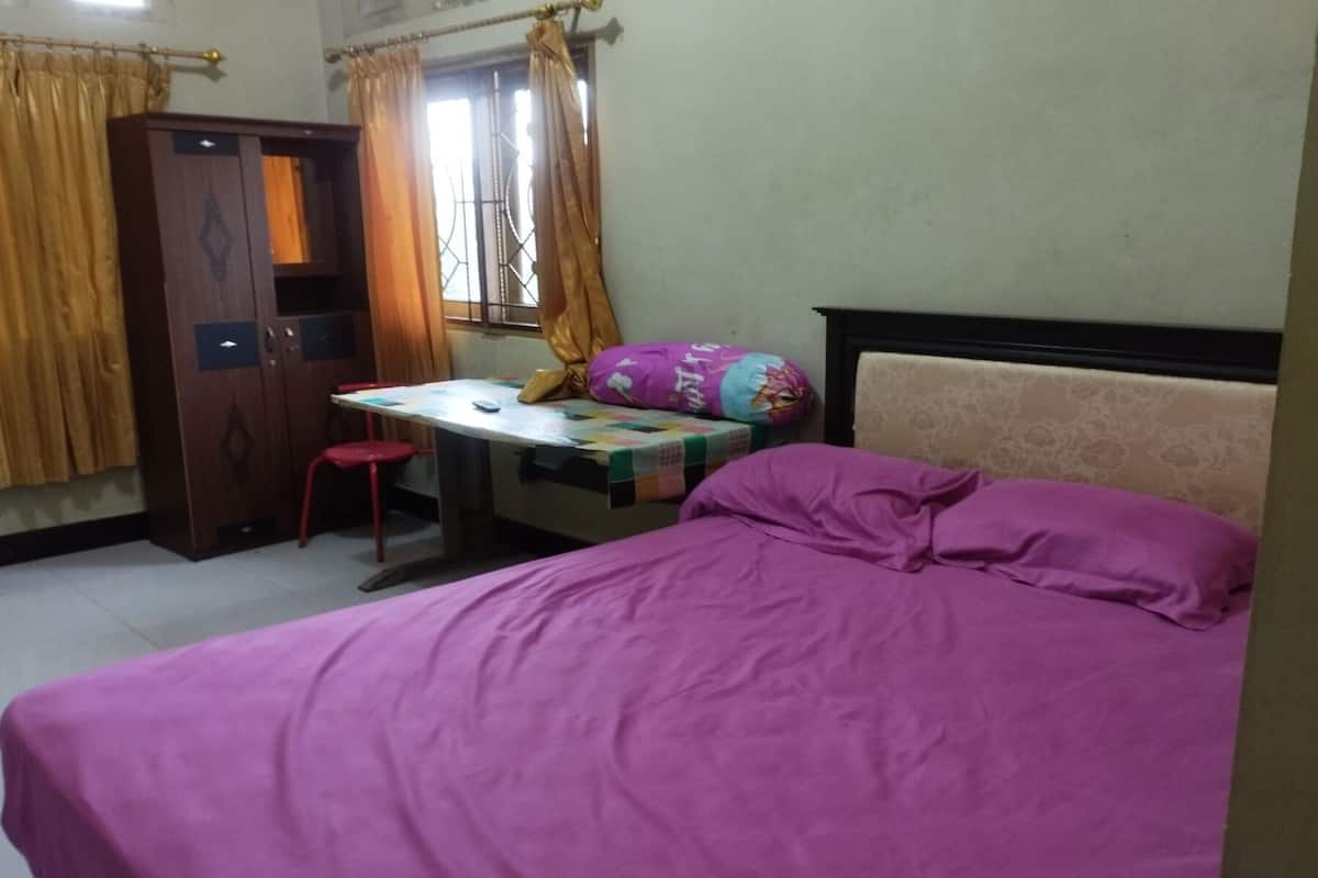 Een slaapkamer met een bed, een bureau en een kledingkast.