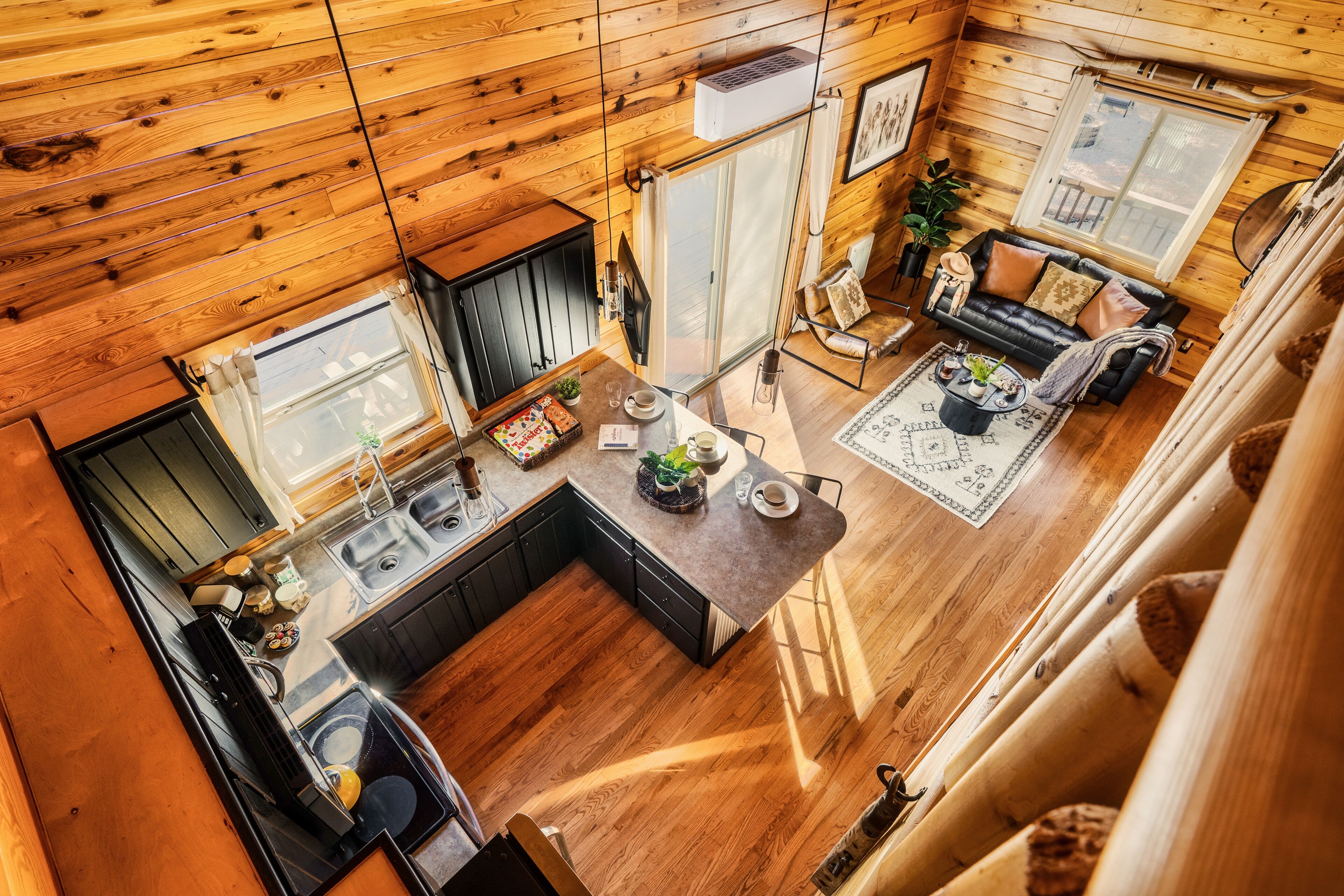 Interior de una cabaña de madera con cocina, comedor y sala de estar.