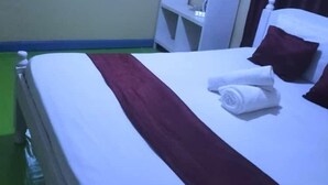 A hotel room with a single bed, a mirror, a wardrobe, and a green carpet. - Lux Suites Chief Engineer Apartments (Mwingi)
