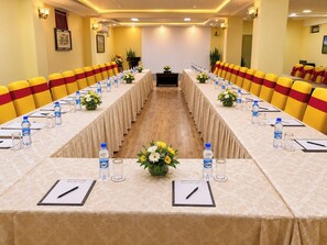 A conference room with a long table, chairs, water bottles, and floral centerpieces. - Punakha Residency Hotel (Punakha)