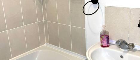 A bathroom with a bathtub, a sink, and a shower.