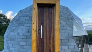 A geodesic dome structure with a wooden door and a glass entrance. - Domo do Matto (Garanhuns)