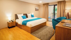 Una habitación de hotel con una cama de madera, un escritorio y una silla.