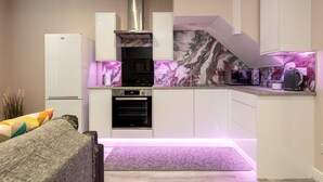 A compact kitchen with a built-in oven, microwave, and a stainless steel range hood.