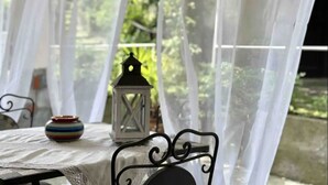 A table with a white tablecloth, a striped ceramic pot, and a white lantern. - Spacious 95 sqm newly renovated vacation home with breathtaking views (Menaggio)