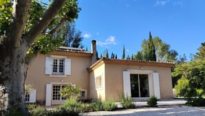 A two-story building with a gravel driveway, white shutters, and a tiled roof.