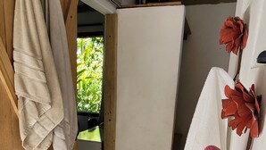 A bathroom with wooden beams, a white sink, and towels hanging on the wall.