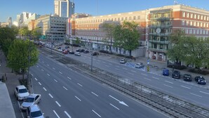 Una calle urbana con edificios, una línea de tranvía y automóviles.