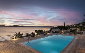Una piscina al aire libre, sombrillas, tumbonas