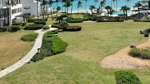 A resort with a pool, palm trees, and a clear view of the ocean. - Modern Studio With Ocean View in Punta Palmera (Punta Cana)