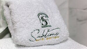 A white towel with embroidered text and logo, likely indicating a hotel or boutique establishment. - Hotel Sublime (Cartagena)