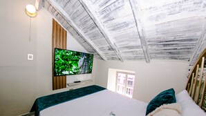 A bedroom with a bed, a TV mounted on the wall, and a window. - Hotel Sublime (Cartagena)
