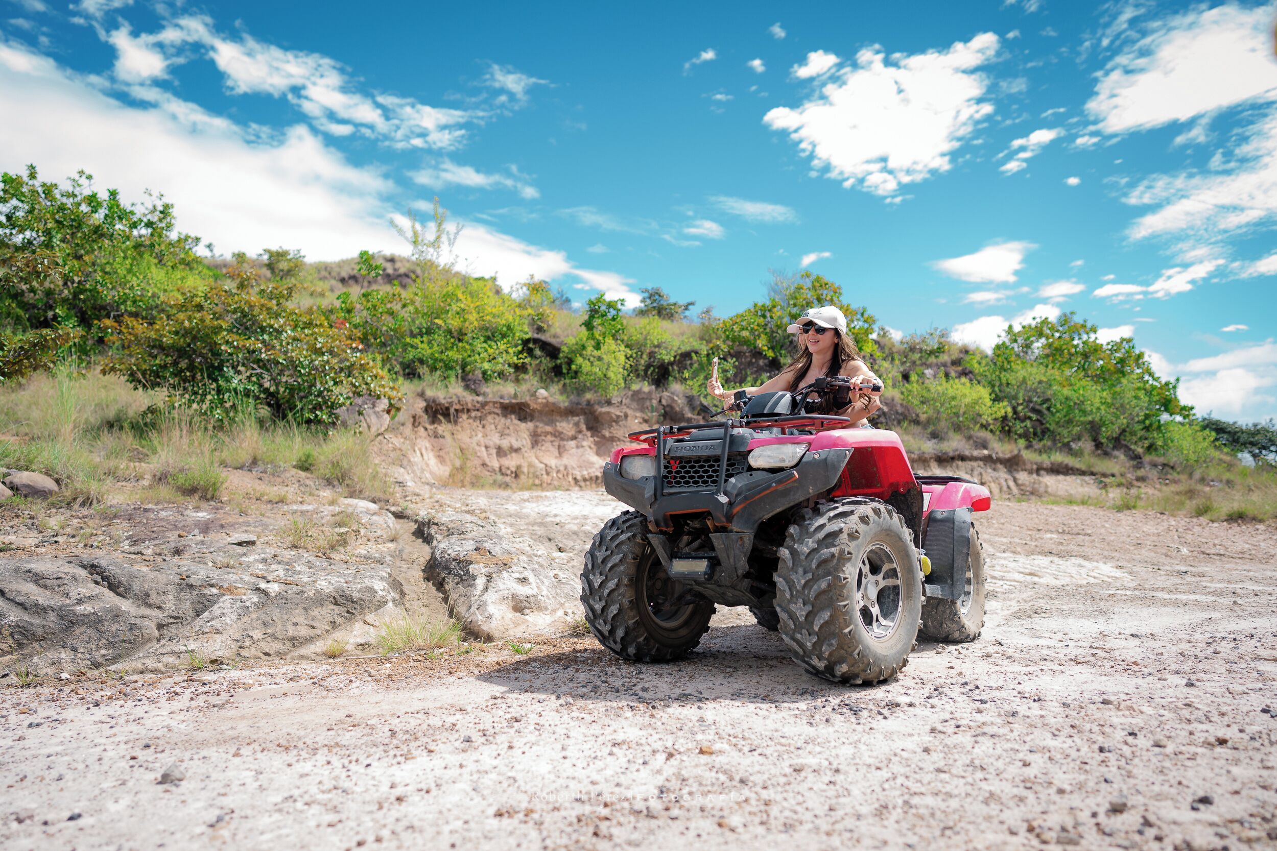 A person riding a red ATV on a dirt path.