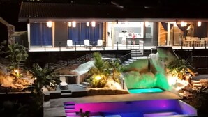 Un hôtel moderne doté d’une piscine, d’un espace extérieur aménagé et d’un escalier menant à l’entrée.