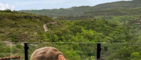 A person receiving a massage on a table with a scenic view of a green landscape and hills in the background.