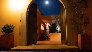 An arched entrance to a building at night with a bright light source above.