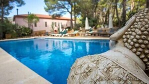 A swimming pool with lounge chairs and a building in the background.