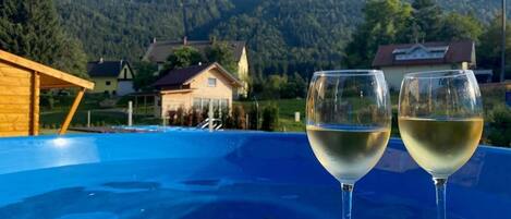 Two glasses of white wine on a blue surface with a mountainous landscape in the background.