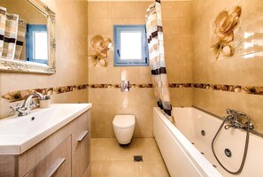 A bathroom with a sink, toilet, and bathtub.