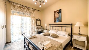 Une chambre à coucher avec un lit, des tables de chevet, une commode, un miroir et un tableau au mur.