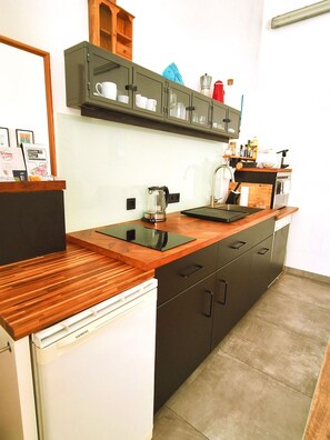 A modern kitchen with a wooden countertop, a built-in coffee maker, and a Siemens refrigerator. - Yellow Palm - 60m2 - cozy, central with a green view (Wien)