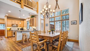 A spacious kitchen with wooden cabinets, a large island, and a dining area with wooden chairs. - Frisco Ski Home, New Hot Tub, Fireplace, Near 3 Resorts, Sleeps 10 (Frisco)