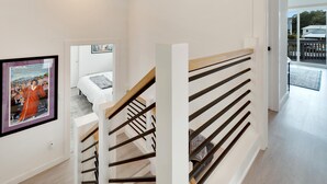 Una escalera moderna con barandillas de madera y una pared blanca.