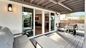 Un patio exterior con un sofá, sillas y una mesa.