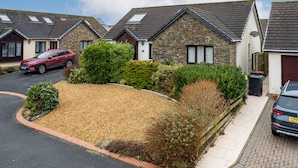 A row of stone houses with pitched roofs, a gravel driveway, and parked cars. - Kittiwake - Short Walk to Beach and Village (Saundersfoot)
