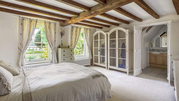 Ein Schlafzimmer mit einem großen Bett, einem Schminktisch, einem Kleiderschrank und einem Badezimmer.