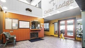 Aulassa on vastaanottotiski, oleskelualue ja kyltti, jossa lukee: ”Cedar Lodge”.
