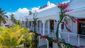 Un bâtiment blanc avec une enseigne indiquant « PLIE WHITE HOUSE » et un balcon doté de balustrades blanches.