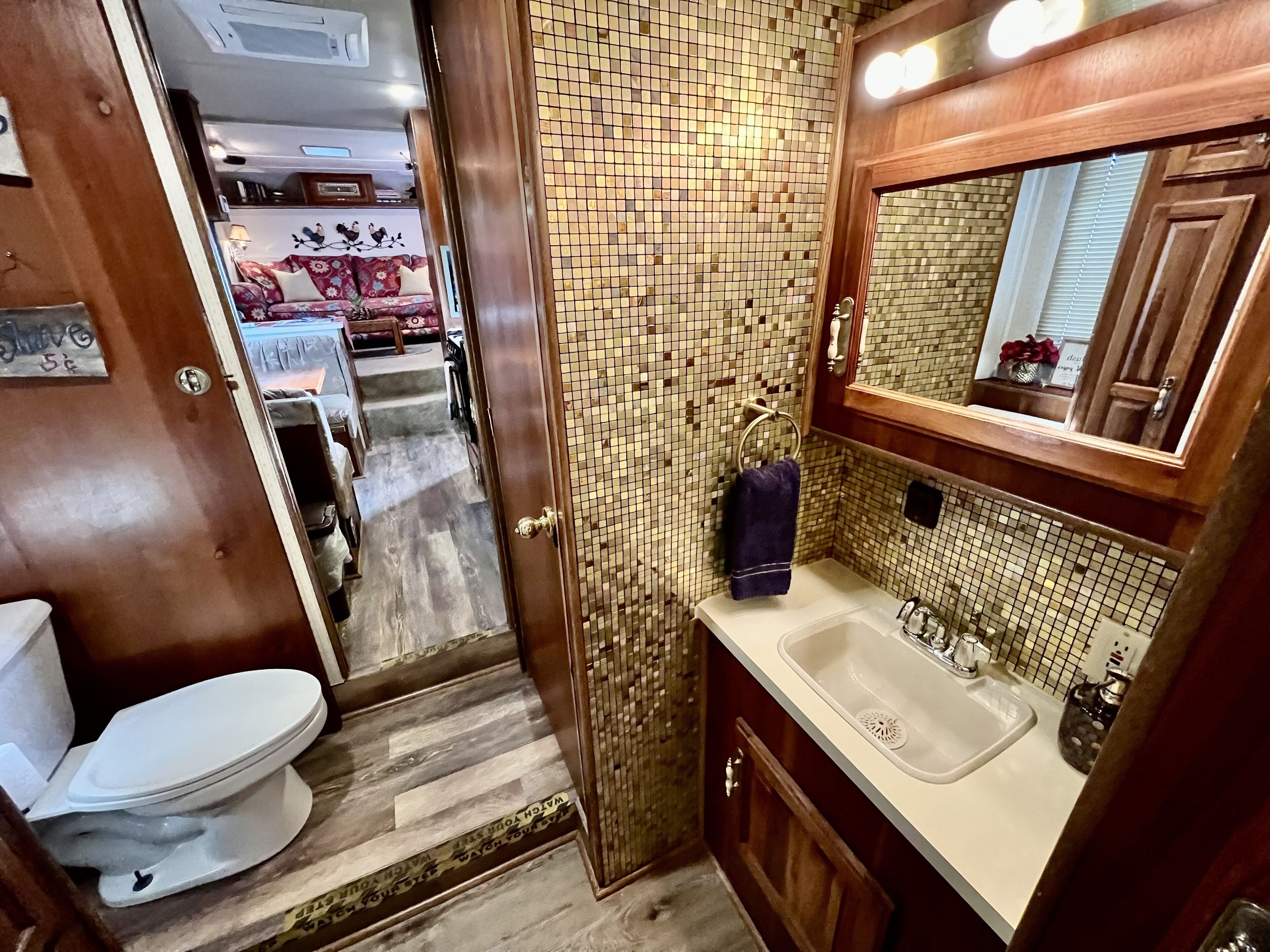 A bathroom with a tiled backsplash, a sink, and a mirror.