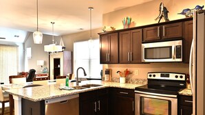 A modern kitchen with dark wood cabinets, stainless steel appliances, and granite countertops. - Beautiful House-Owner's Secrete Treasure, Private Backyard, 3 min to the Beach! (Myrtle Beach)