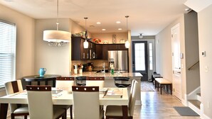 A modern kitchen with dark cabinetry, a central island, and pendant lighting. - Beautiful House-Owner's Secrete Treasure, Private Backyard, 3 min to the Beach! (Myrtle Beach)