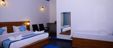 Habitación de hotel con dos camas, un escritorio y un espejo.