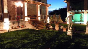 A stone building with a porch, steps, and potted plants.
