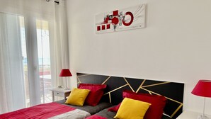 Camera d'albergo moderna con un letto grande, due comodini e vista sull'esterno.
